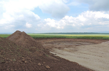 Der Fundamentbau wird mit dem Baugrubenaushub vorbereitet. Neben der Baugrube lagert der abgetragene Mutterboden.