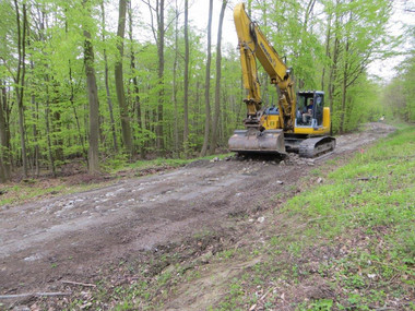 Ein Baufahrzeug setzt den Forstweg wieder instand