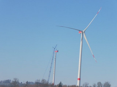 Eine fertige und eine im Bau befindliche Windenergieanlage ragen nahe in Trendelburg aus dem Wald