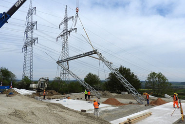 Das Hochspannungsportal wird aufgestellt. Die Bodenplatten sind gegossen.