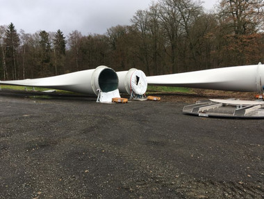 drei Rotorblätter lagern auf der Baustelle