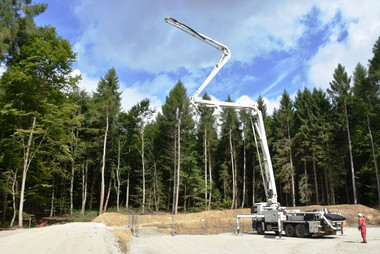 Betonpumpe neben Baugrube am Rand der Baugrube wird eine Betonpumpe in Position gebracht