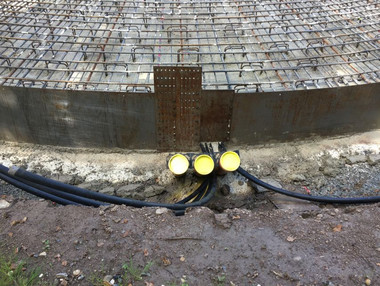 Aus dem im Bau befindlichen Fundament ragen Leerrohre für Stromkabel