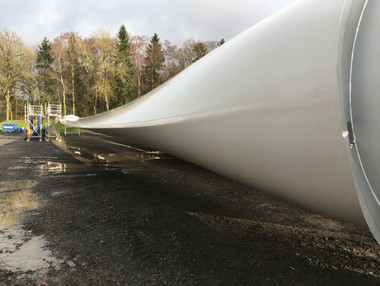 Das Rotorblatt einer Windenergieanlage lagert auf einer Baustelle