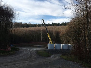 Turmsegmente Betonhalbschalen lagern neben dem fertigen Fundament